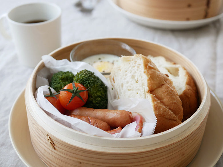 ほったらかし電気せいろと新鮮な野菜や食器が並ぶ調理シーン