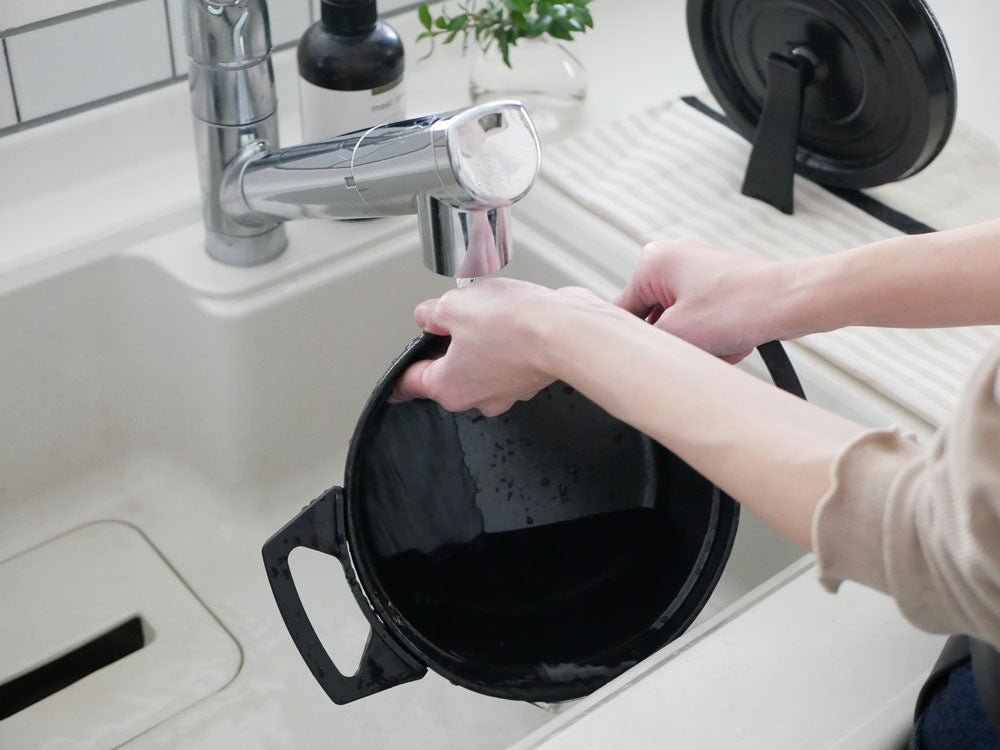 水無し電気鍋 KO TSU I RA ZUがキッチンカウンターに置かれ、周囲に鍋セットや調理器具が並んでいる様子