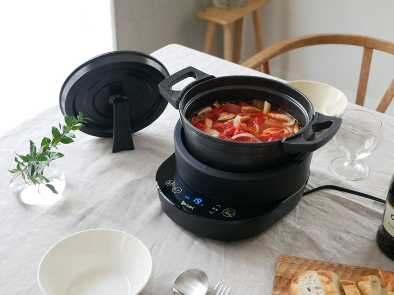 電気鍋「コツイラズ」と付属の鍋セットがキッチン用品と一緒に写っている