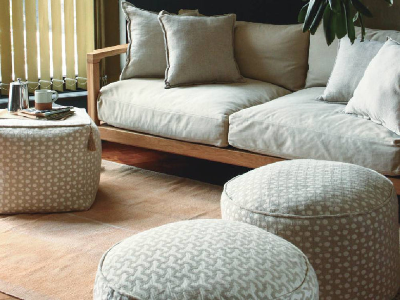 グレーのフレンチリネンビーズクッションがリビングルームのソファに置かれ、快適な雰囲気を演出している様子