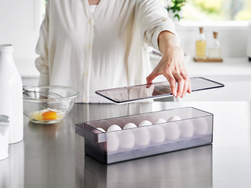 冷蔵庫の棚に「tower / タワー」冷蔵庫中蓋付き卵ケースが置かれ、14個の卵が整然と収納されている様子