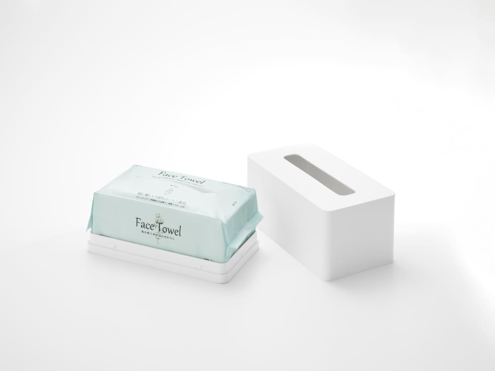 Towerフィルムフッククレンジングタオルケースとフェイシャルティッシュホルダーが収納された段ボール包装。ギフト用のパーソナルケア用品として家庭内で使用可能
