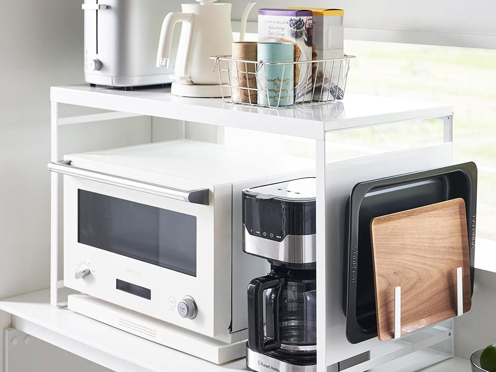 タワー型スチールパネル付きレンジラック。キッチンに設置され、複数の棚で調理器具や小型家電を収納できるデザイン。