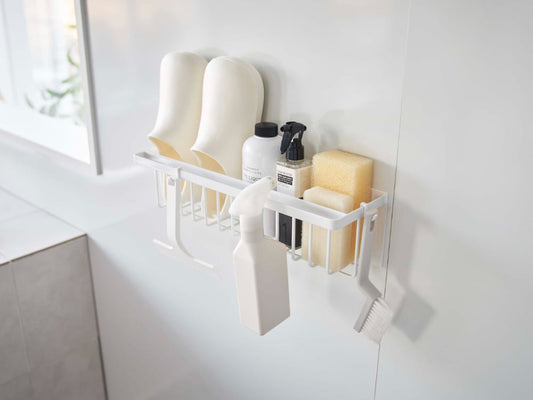 スチール製マグネットバスルームバスケットが平らな壁面に取り付けられ、洗面用具やキッチン用品を整理している様子