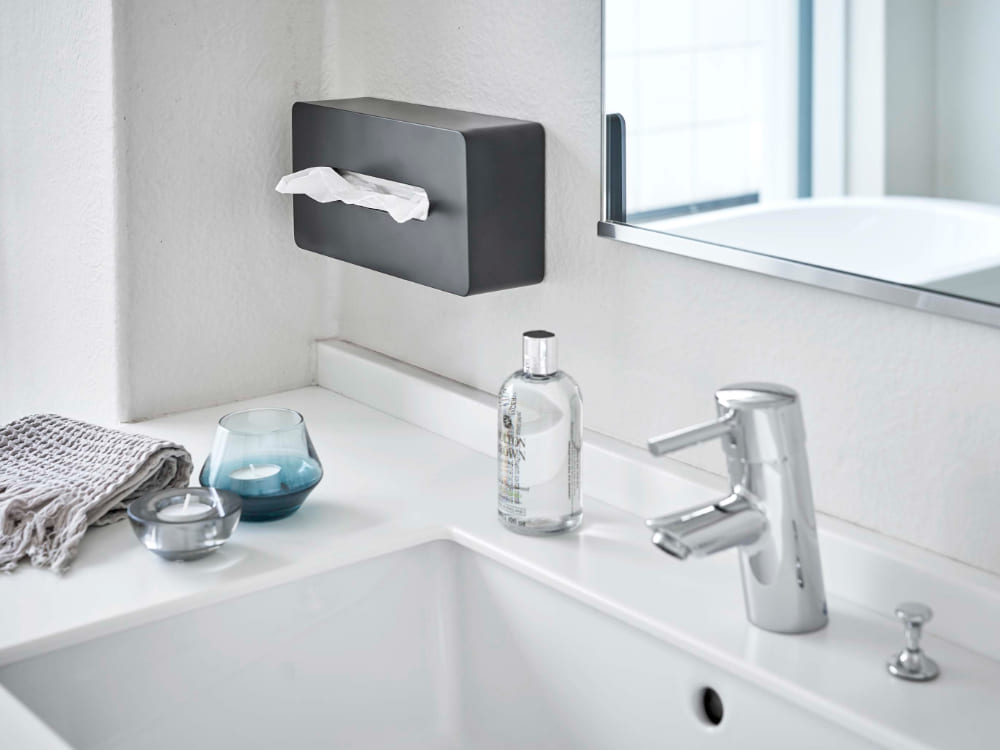タワーシリーズのレギュラーサイズティッシュケースがバスルームのシンク台に設置されており、蛇口や洗面キャビネット、ソープディスペンサーなどの浴室設備が整っている様子