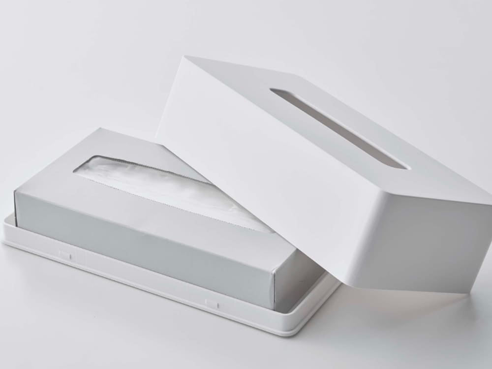 レギュラーサイズのタワー型プラスチック製ティッシュケースに紙ティッシュが入っている