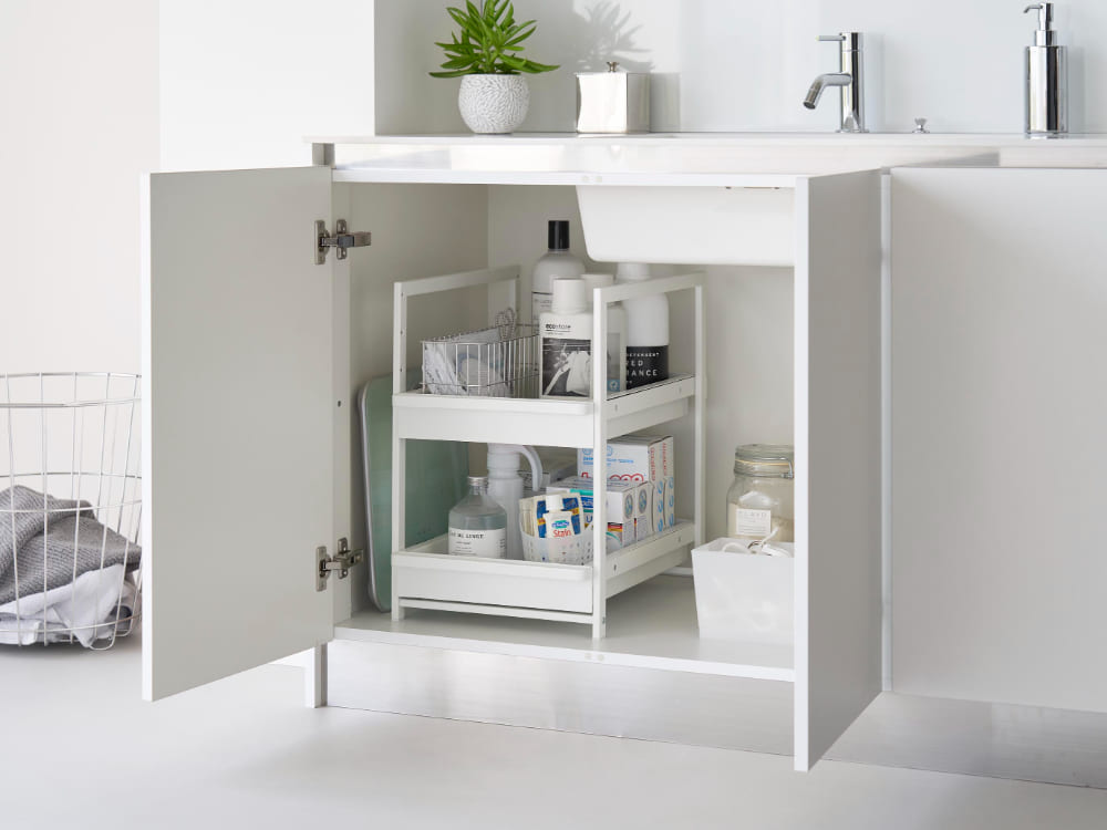 灰色のシンク下に設置されたタワー型浴室キャビネット、スライド式の引き出しと複数の棚を備えたインテリア家具