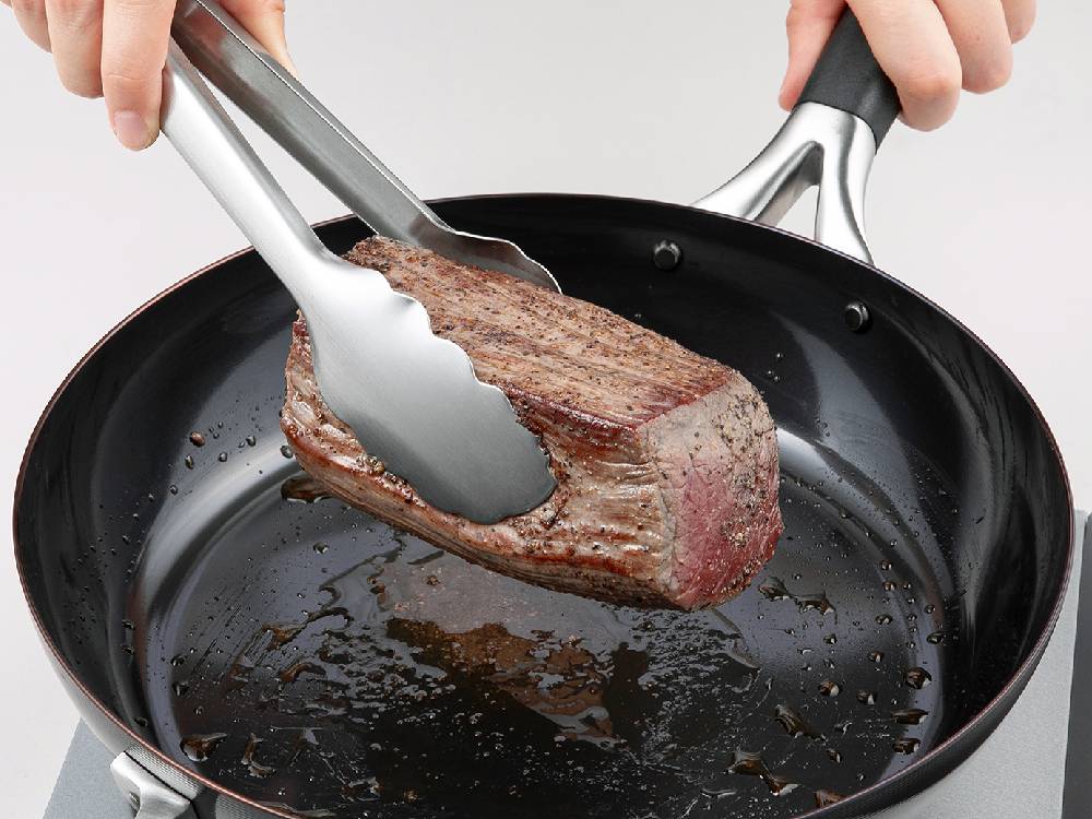 SELECT100の24cmトング。18-8ステンレススチール製本体と耐熱ABS樹脂製の持ち手を持つキッチン用調理器具