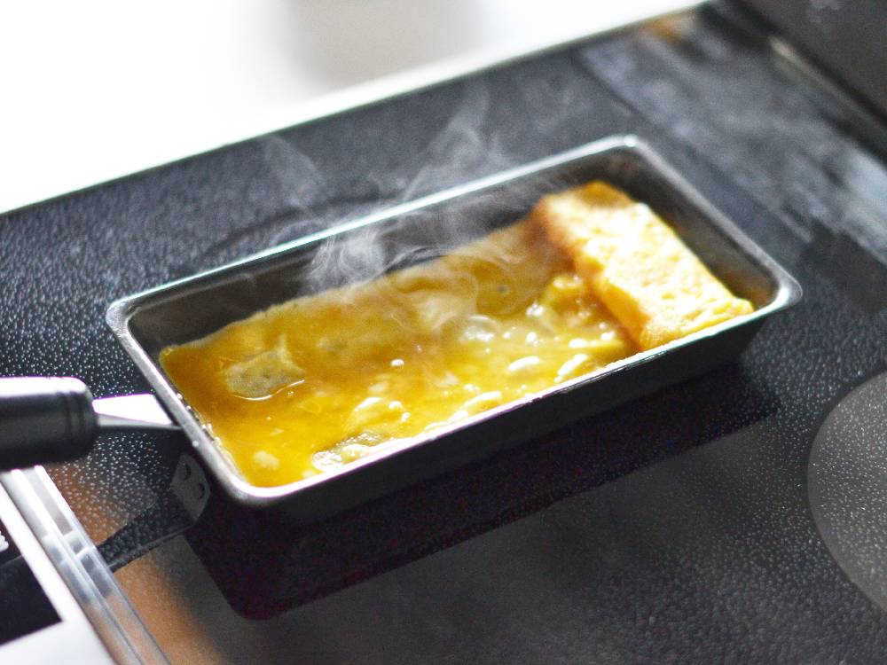 鉄製卵焼き器で卵を調理中の様子