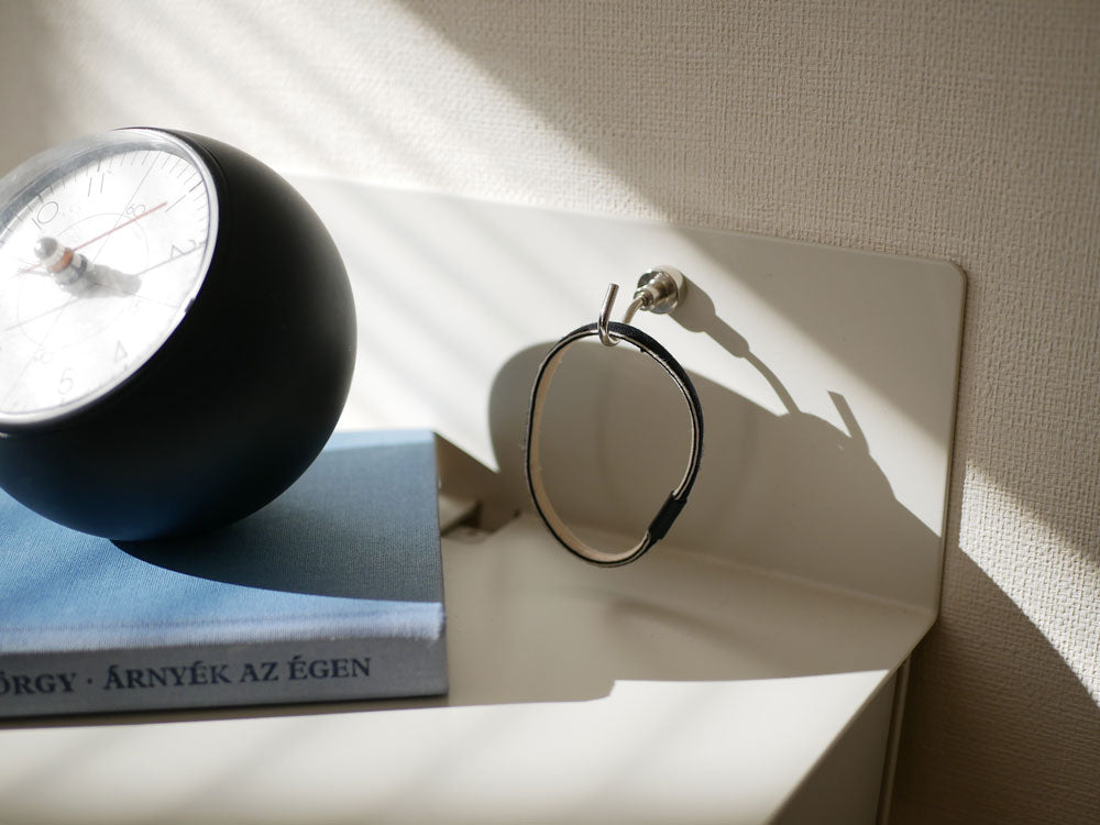 スチール製イデアコウォールテーブルB5上にシルバーの目覚まし時計がバランス良く配置された静物写真