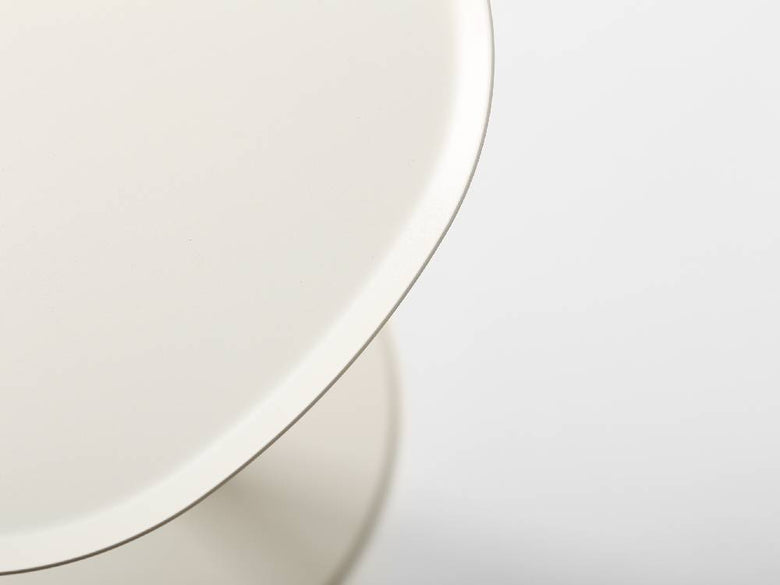 イデアコ スチールファニュチャー サイドテーブル23の上に、デザイン性の高い円形の磁器皿とソーサーが配置されたコーヒーテーブル