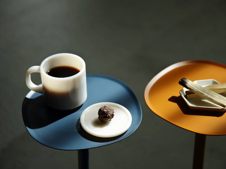 ideaco（イデアコ）のスチールファニュチャー サイドテーブル23の上に置かれた陶器製のカップや皿などのテーブルウェア