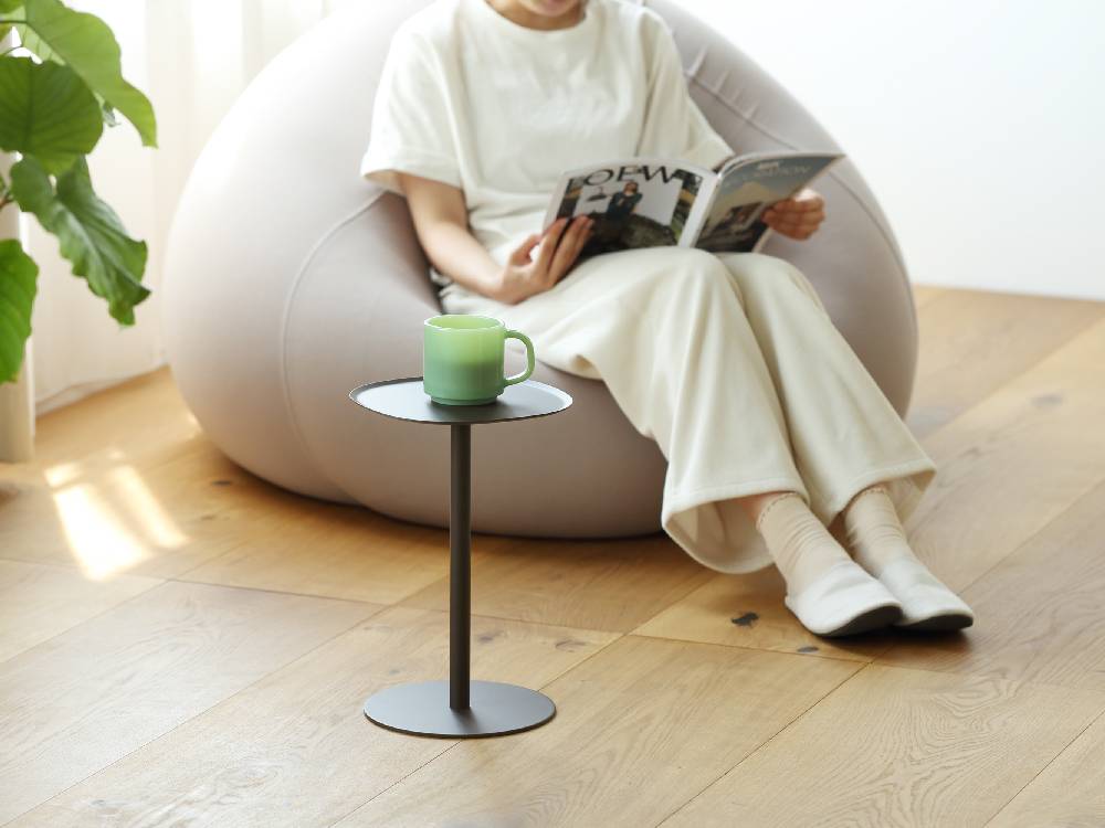 リビングルームに配置されたイデアコのスチールサイドテーブル23、木製フローリングと椅子、ハウスプランツが調和したインテリア