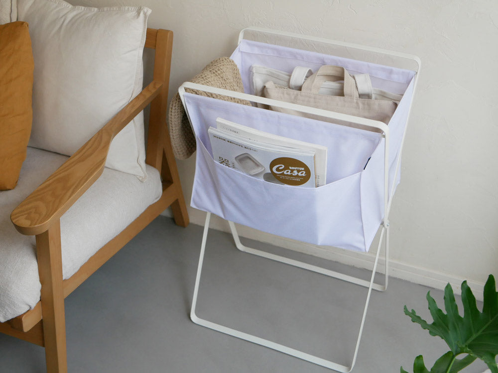 タワー折り畳み高床ランドリーバスケットとソファが並ぶリビング